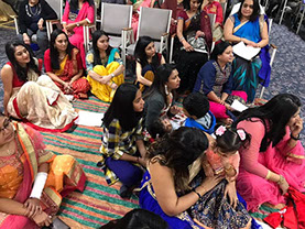 photo shows women sitting down at an event for Gujarati Samaj.