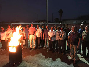 photo of men gathered at HOLI around a fire in 2017.